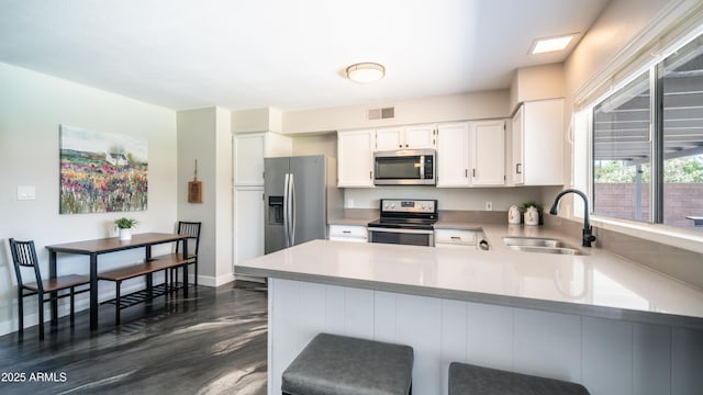 2139 W Obispo Ave, Mesa, AZ 85202 - kitchen featuring appliances with stainless steel finishes, a sink, light countertops, white cabinets, and a peninsula