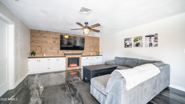 2139 W Obispo Ave, Mesa, AZ 85202 - living area featuring dark wood-style flooring, baseboards, a tiled fireplace, ceiling fan, and wood walls