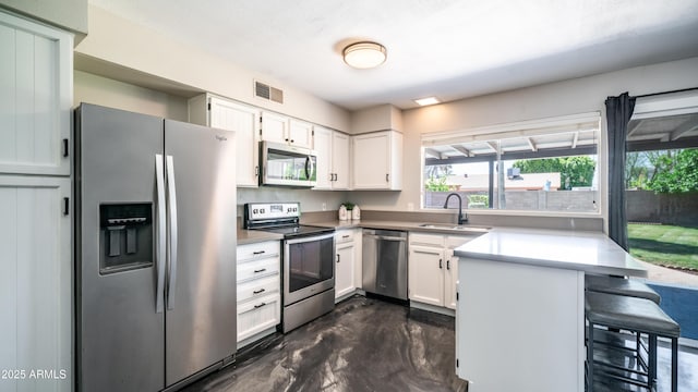 2139 W Obispo Ave, Mesa, AZ 85202 - kitchen featuring stainless steel appliances, a sink, a peninsula, a kitchen breakfast bar, and white cabinets