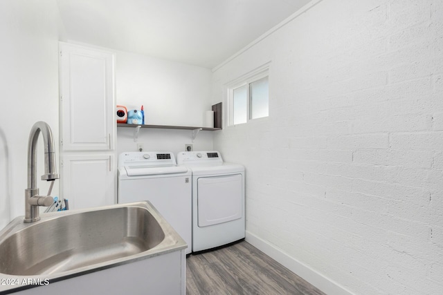 clothes washing area with sink, dark wood-type flooring, and independent washer and dryer