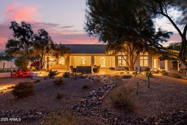 view of front facade with an outdoor living space and a patio