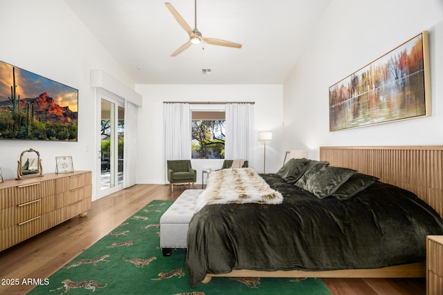 bedroom with ceiling fan, high vaulted ceiling, access to exterior, and hardwood / wood-style floors