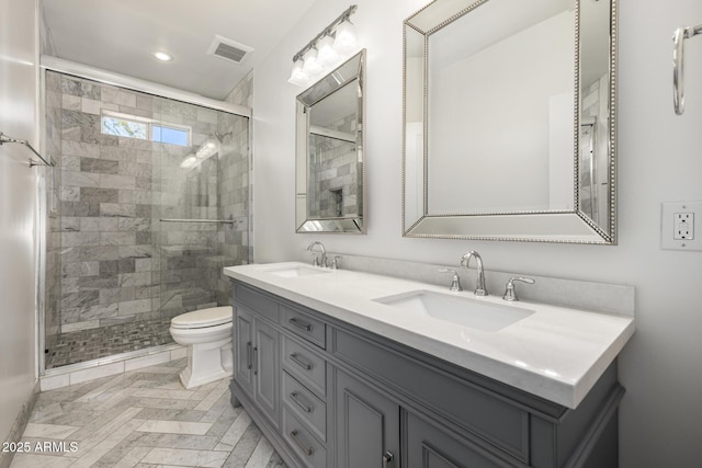 bathroom featuring vanity, toilet, and a shower with shower door