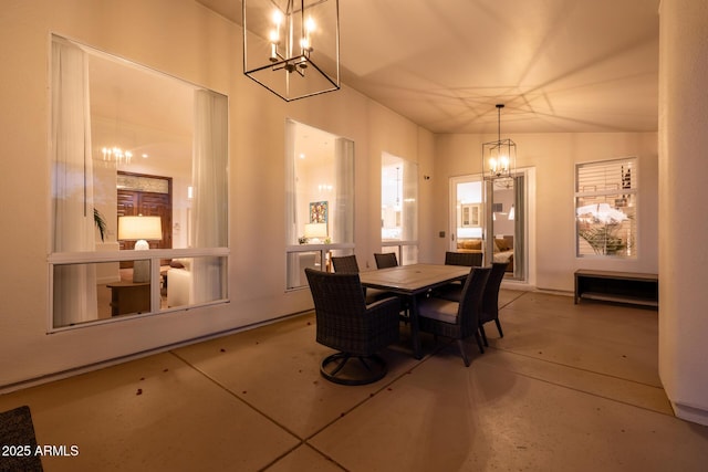 dining room with an inviting chandelier and concrete flooring