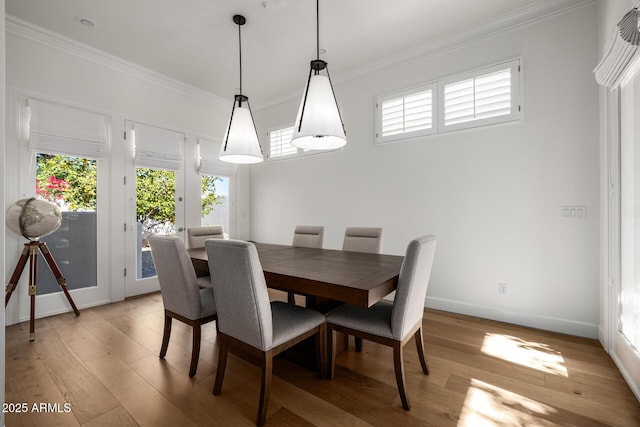 dining room with plenty of natural light, ornamental molding, and light wood-type flooring