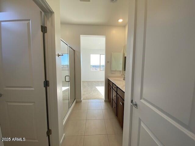 full bath with tile patterned floors, visible vents, a shower stall, and vanity