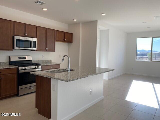 kitchen featuring visible vents, a sink, light stone counters, recessed lighting, and appliances with stainless steel finishes