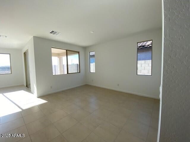 spare room with visible vents, baseboards, and a healthy amount of sunlight