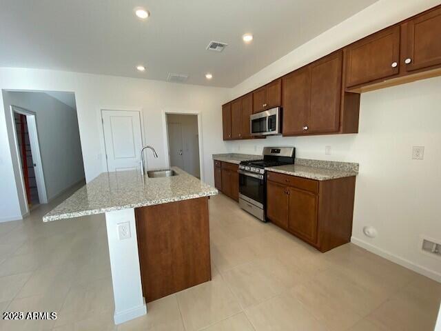 kitchen with visible vents, light stone countertops, recessed lighting, stainless steel appliances, and a sink