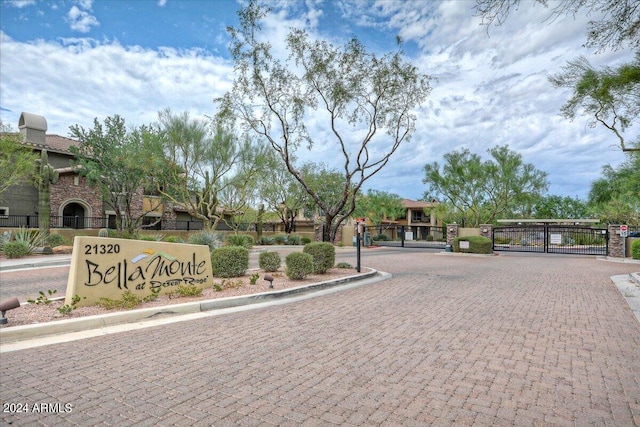 view of street featuring a gated entry, curbs, and a gate