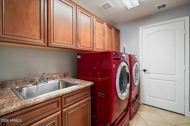 washroom featuring a sink, visible vents, cabinet space, and independent washer and dryer