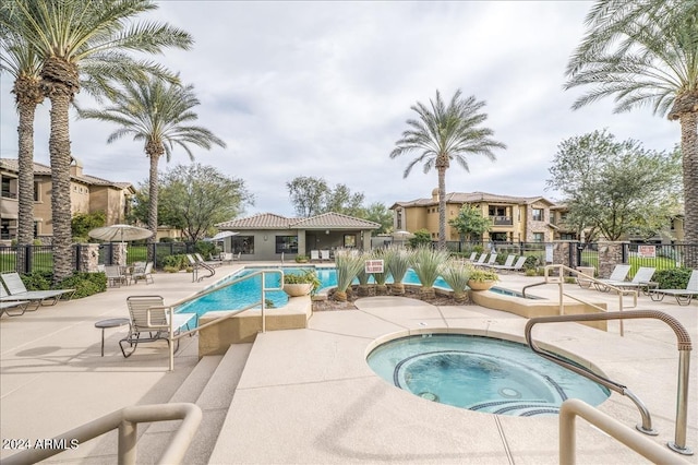 pool featuring a patio, fence, and a hot tub