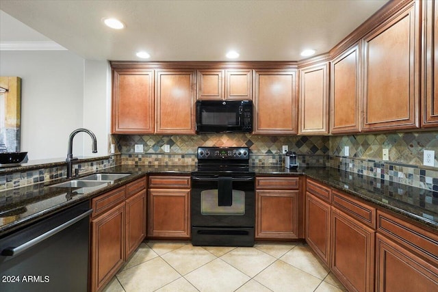 kitchen featuring black appliances, a sink, backsplash, dark stone counters, and light tile patterned flooring