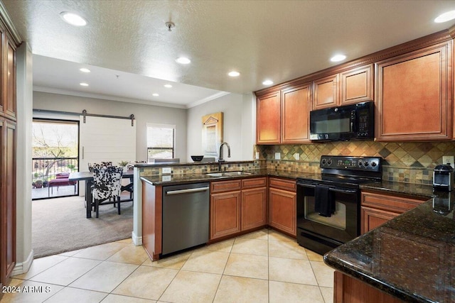 kitchen with a sink, black appliances, a peninsula, and light tile patterned floors