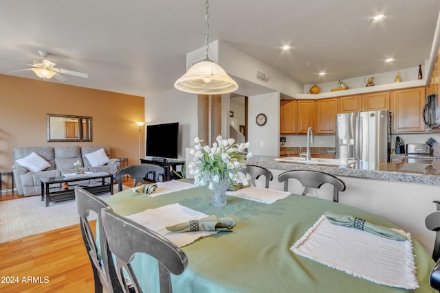 dining room featuring light hardwood / wood-style floors, sink, and ceiling fan