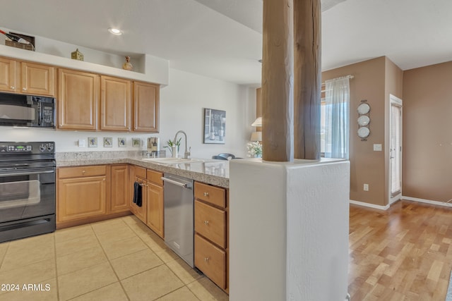 kitchen with light hardwood / wood-style floors, black appliances, and sink