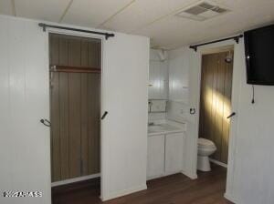 bathroom featuring hardwood / wood-style flooring and toilet