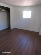 unfurnished bedroom with dark hardwood / wood-style flooring and a closet