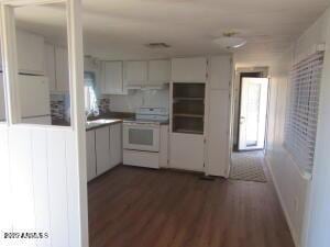 kitchen featuring dark wood-type flooring, white cabinets, and electric range