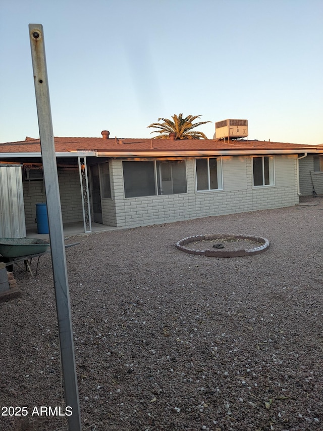 back house at dusk featuring a patio area