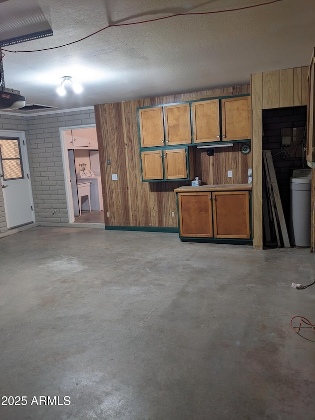 garage with a garage door opener and wood walls