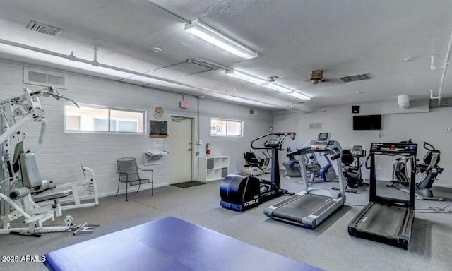 gym with plenty of natural light and a textured ceiling