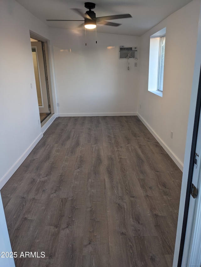 unfurnished room featuring dark wood-type flooring, a wall mounted air conditioner, and ceiling fan