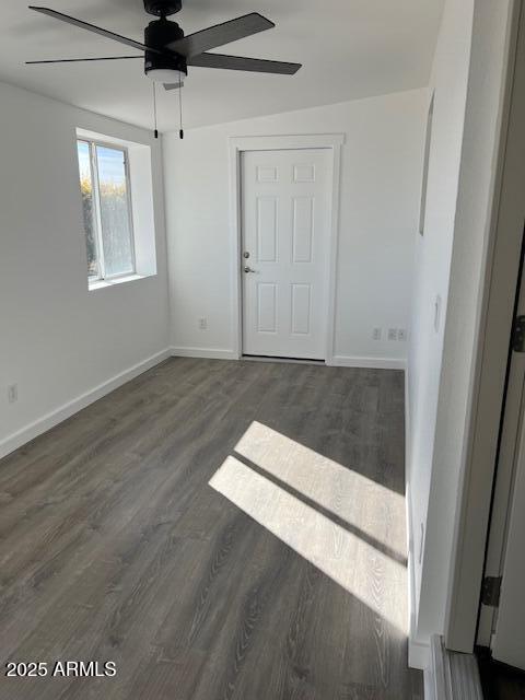 empty room featuring ceiling fan and dark hardwood / wood-style floors