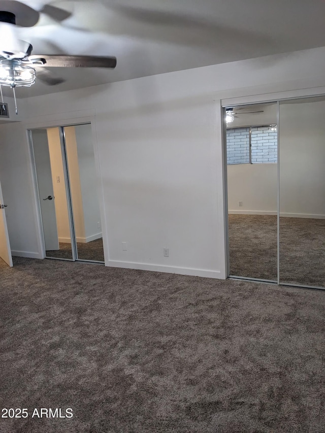 unfurnished bedroom featuring dark carpet and ceiling fan