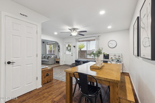 dining area featuring a ceiling fan, recessed lighting, dark wood-style flooring, baseboards, and arched walkways