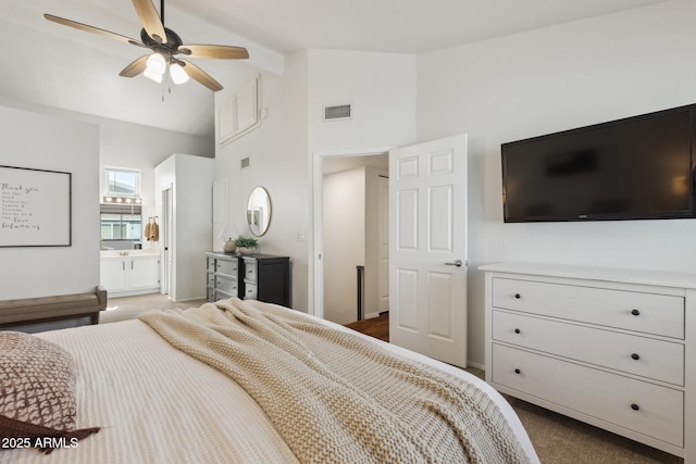 bedroom with dark colored carpet, high vaulted ceiling, ensuite bath, and baseboards