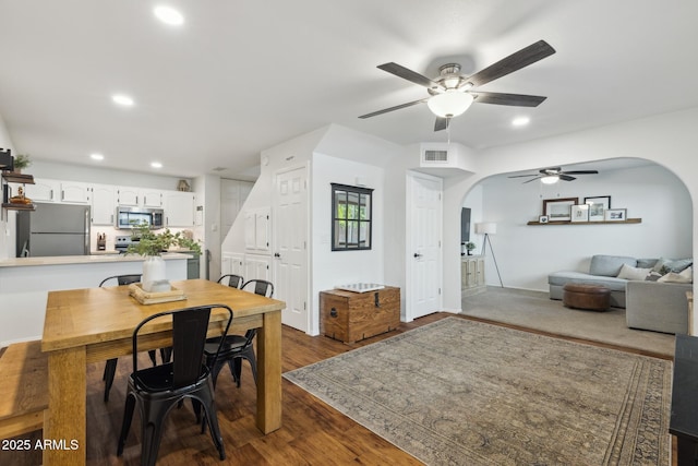 home office featuring arched walkways, ceiling fan, dark wood finished floors, and recessed lighting