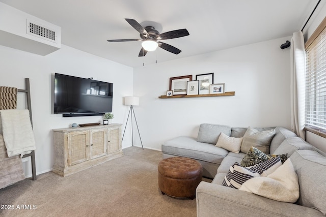 living area with a ceiling fan, carpet, and baseboards