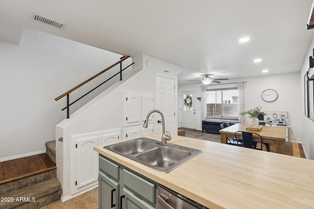 kitchen with a sink, wood counters, ceiling fan, recessed lighting, and baseboards