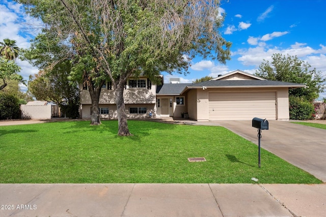tri-level home with driveway, an attached garage, a front yard, and stucco siding