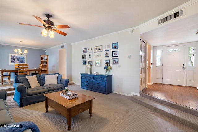 living area featuring baseboards, crown molding, a chandelier, a ceiling fan, and light carpet