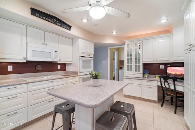 kitchen with white appliances, white cabinetry, light tile patterned flooring, and recessed lighting