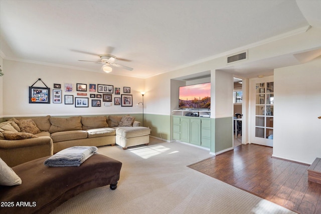 living area with crown molding, ceiling fan, and wood finished floors