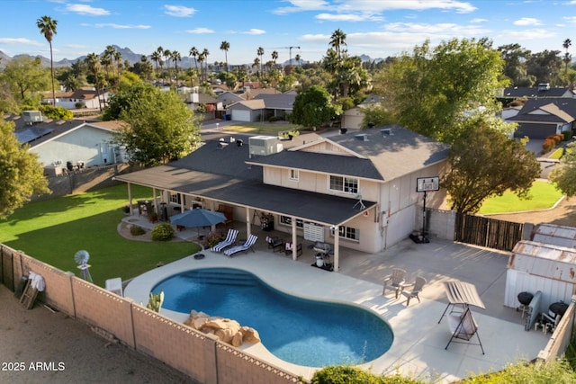 view of swimming pool with a residential view, a patio, a gate, and a mountain view