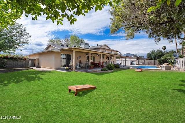 rear view of property featuring stucco siding, a ceiling fan, and a patio area