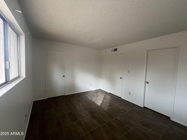 unfurnished bedroom with a textured ceiling