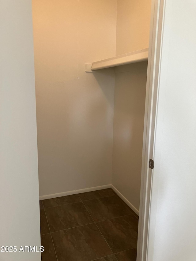 walk in closet featuring dark tile patterned floors