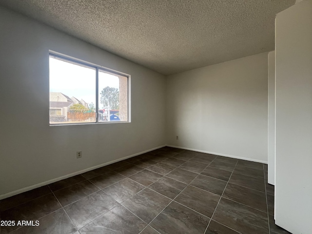 tiled empty room with a textured ceiling