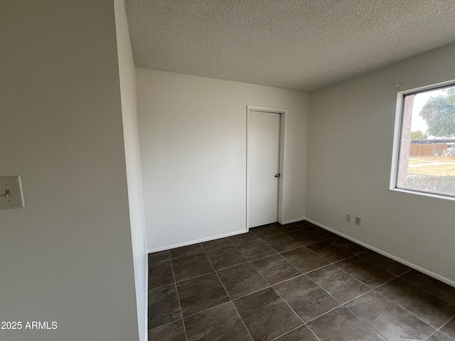 unfurnished room featuring a textured ceiling