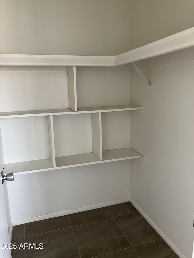 spacious closet with dark tile patterned flooring