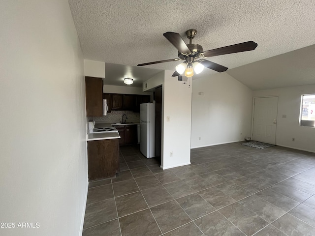 kitchen with ceiling fan, white appliances, a textured ceiling, and backsplash