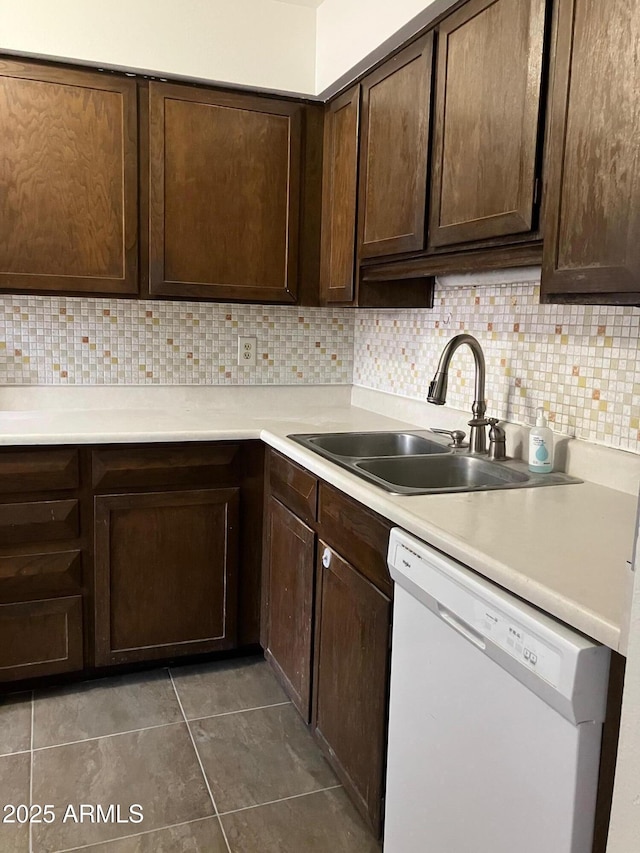 kitchen with tasteful backsplash, sink, dark brown cabinets, and dishwasher