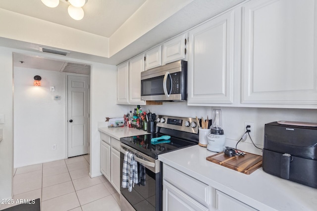 kitchen with white cabinetry, appliances with stainless steel finishes, and light tile patterned floors