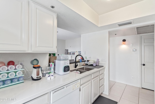 kitchen featuring dishwasher, sink, light tile patterned flooring, and white cabinets