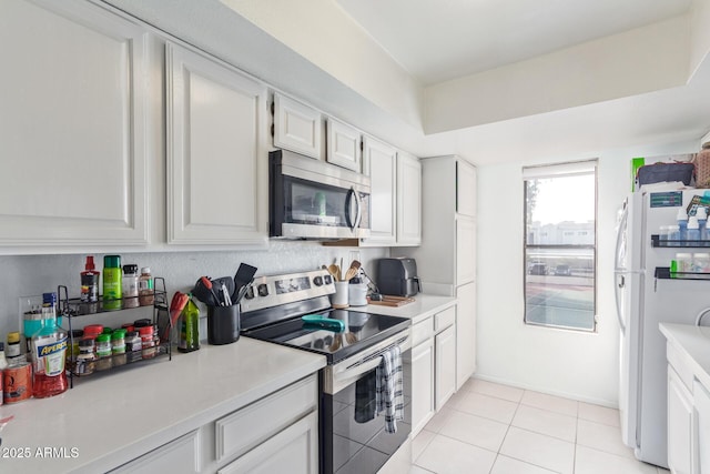 kitchen featuring stainless steel appliances, white cabinets, and light tile patterned flooring